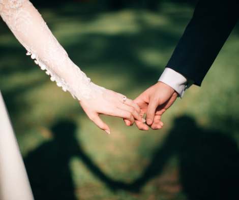 bride and groom holding hands outdoors