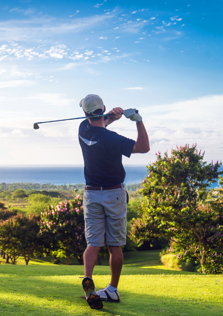 Man teeing off at a golf course with a lovely view
