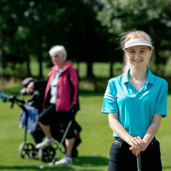 Young golfer playing a round of golf with her mother and grandmother